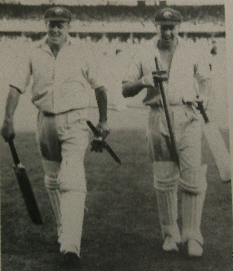 Ring (right) and Bill Johnston (left) leave the field after their unbroken last wicket stand guided Australia to victory over the West Indies in the Fourth Test at the MCG in 1951–52.
