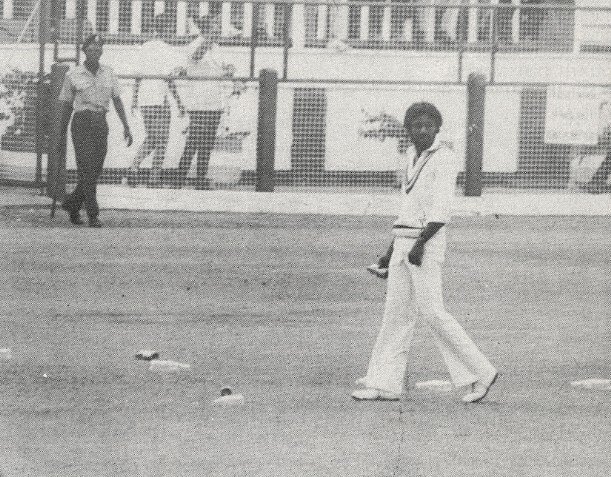 Wasim Raja picks up debris after the crowd hurled bottles and cans onto the outfield during the 3rd WI v Pakistan Test at Georgetown in March 1977.